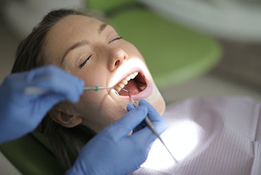 woman getting her teeth checked at the general dentist